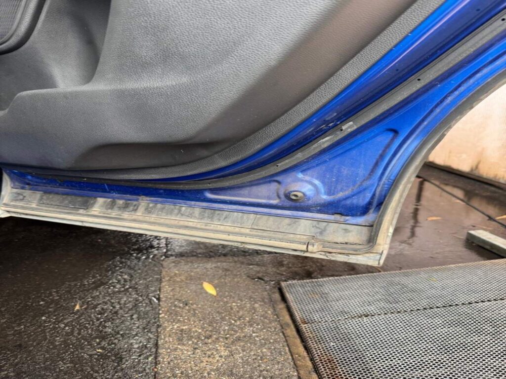 Grimy car door sill before professional wash at The Washouse